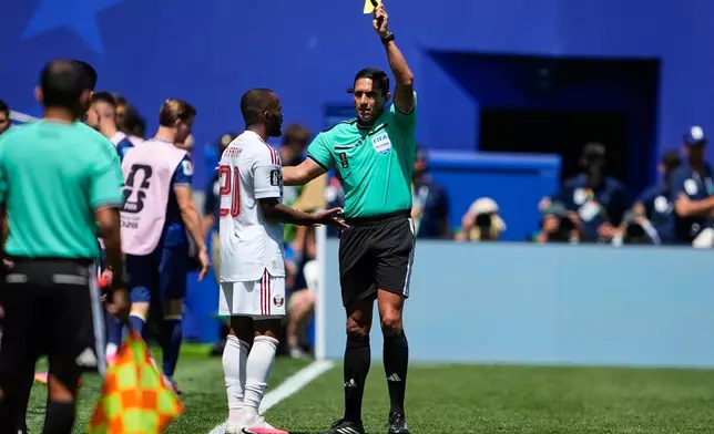 Referee Jesús Valenzuela, right, shows Qatar's Ahmed Fathy a yellow card during the World Cup Group B soccer match against Bosnia in Seattle, Wednesday, June 24, 2026. (AP Photo/Lindsey Wasson)