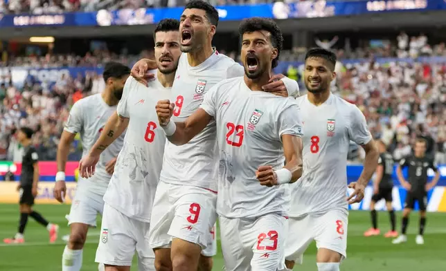 Iran's Ramin Rezaeian (23) celebrates with his teammates after scoring a goal during the World Cup Group G soccer match between Iran and New Zealand in Inglewood, Calif., near Los Angeles, Monday, June 15, 2026. (AP Photo/Andre Penner)