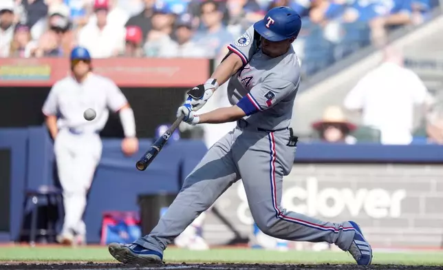 Texas Rangers' Corey Seager hits a solo home run during the sixth inning of a baseball game against the Toronto Blue Jays in Toronto, Saturday, June 27, 2026. (Nathan Denette/The Canadian Press via AP)