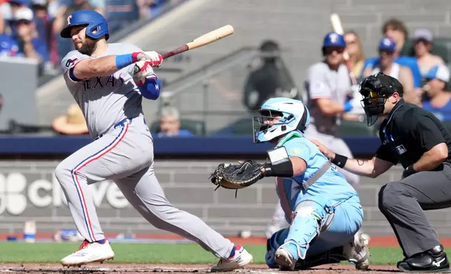 Texas Rangers first baseman Jake Burger (21) hits a single during fifth inning of a baseball game against the Toronto Blue Jays, in Toronto, Saturday, June 27, 2026. (Nathan Denette/The Canadian Press via AP)