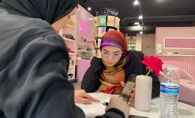 Maya Attoui, left, and Marwa Mussa discuss plans for a fundraiser while seated at a coffee shop on May 29, 2026, in Dearborn, Mich. (AP Photo/Mike Householder)