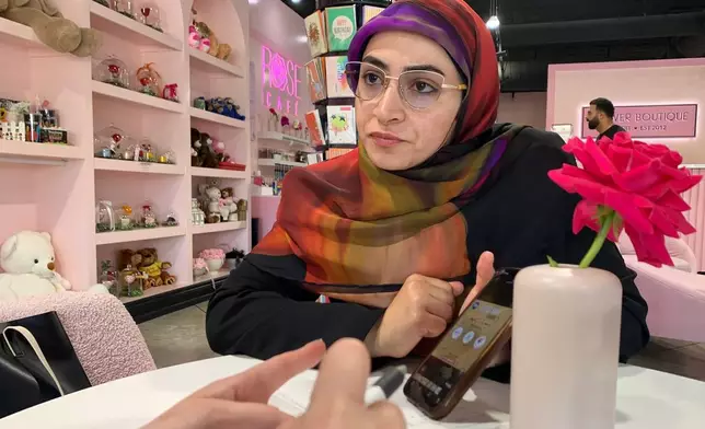 Marwa Mussa discusses plans for a fundraiser while seated at a coffee shop on May 29, 2026, in Dearborn, Mich. (AP Photo/Mike Householder)