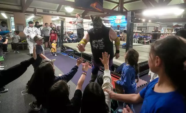 Wrestler Llama Jack greets fans during a Lucha Libro pro wrestling event at Benicia Public Library Saturday, May 2, 2026, in Benicia, Calif. (AP Photo/Jeff Chiu)