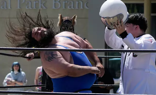 Wrestler Victor Von Richter, left, reacts after being hit by Astro Knox, right, in a Lucha Libro pro wrestling match at the San Jose Public Library Educational Park Branch Saturday, May 9, 2026, in San Jose, Calif. (AP Photo/Jeff Chiu)