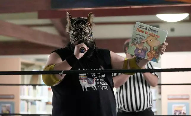 Wrestler Llama Jack reads a Llama Llama book in the ring during a Lucha Libro pro wrestling event at Benicia Public Library Saturday, May 2, 2026, in Benicia, Calif. (AP Photo/Jeff Chiu)