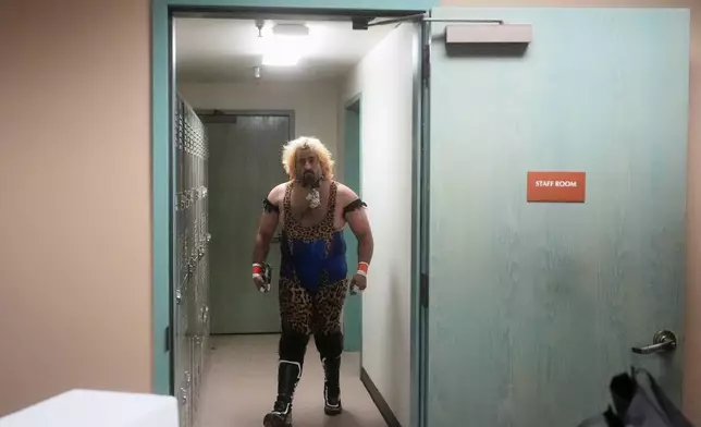 Wrestler Jaguar Montoya prepares for a match during a Lucha Libro pro wrestling event at Benicia Public Library Saturday, May 2, 2026, in Benicia, Calif. (AP Photo/Jeff Chiu)
