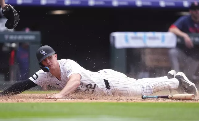 Colorado Rockies' Mickey Moniak scores on a bunt put down by Tyler Freeman in the eighth inning of a baseball game against the Boston Red Sox Wednesday, June 24, 2026, in Denver. (AP Photo/David Zalubowski)