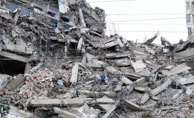 A man walks among the rubble of a building that collapsed in earthquakes the previous day in La Guaira, Venezuela, Thursday, June 25, 2026. (AP Photo/Pedro Mattey)