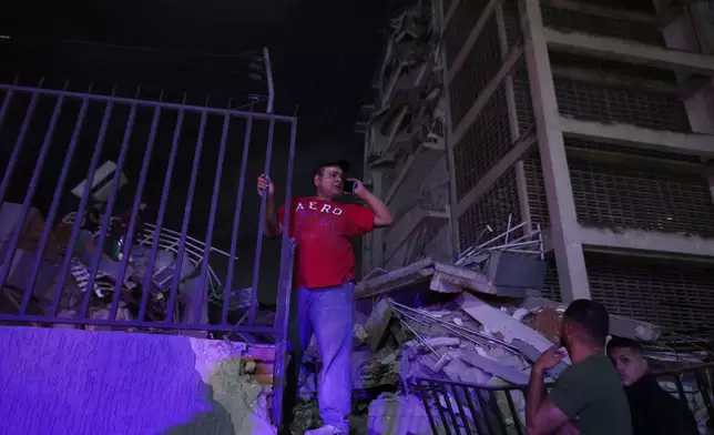 A man tries to make a call after an earthquake in Caracas, Venezuela, Wednesday, June 24, 2026. (AP Photo/Pedro Mattey)