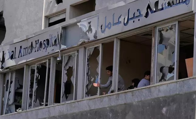 A man looks through the shattered windows of the damaged Jabal Amel Hospital, following Monday's Israeli airstrike that was hit a nearby building, in the southern port city of Tyre, Lebanon, Tuesday, June 2, 2026. (AP Photo/Mohammed Zaatari)
