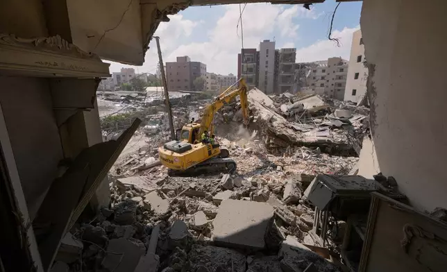 Rescue workers use an excavator, as they search for victims under the rubble of a building that was hit Monday in an Israeli airstrike in the southern port city of Tyre, Lebanon, Tuesday, June 2, 2026. (AP Photo/Mohammed Zaatari)
