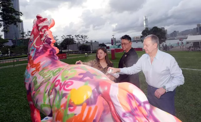 Rosanna Law, Secretary for Culture, Sports and Tourism of the HKSAR Government (left); Winfried Engelbrecht‑Bresges, Chief Executive Officer of The Hong Kong Jockey Club (right); artist Simon Ma (middle) paint “Community Horse” sculptures at the launch ceremony. Photo source: HKJC