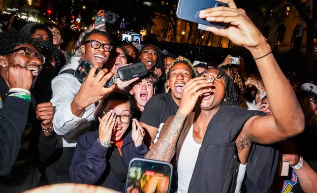 New York Knicks fans watch Game 3 of the NBA Finals basketball series on a smartphone outside of a watch party in Bryant Park, Monday, June 8, 2026, in New York. (AP Photo/Ryan Murphy)