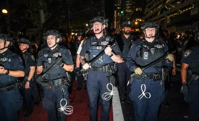 NYPD officers push New York Knicks fans back outside of a watch party in Bryant Park for Game 3 of the NBA Finals basketball series between the Knicks and the San Antonio Spurs, Monday, June 8, 2026, in New York. (AP Photo/Ryan Murphy)