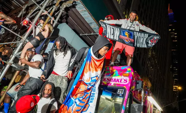 New York Knicks fans celebrate on the street outside of a watch party in Bryant Park for Game 3 of the NBA Finals basketball series between the Knicks and the San Antonio Spurs, Monday, June 8, 2026, in New York. (AP Photo/Ryan Murphy)