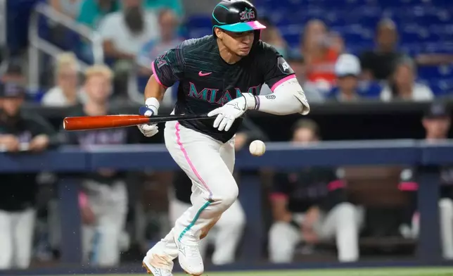 Miami Marlins' Javier Sanoja hits a bunt single during the seventh inning of a baseball game against the San Francisco Giants, Friday, June 19, 2026, in Miami. (AP Photo/Lynne Sladky)