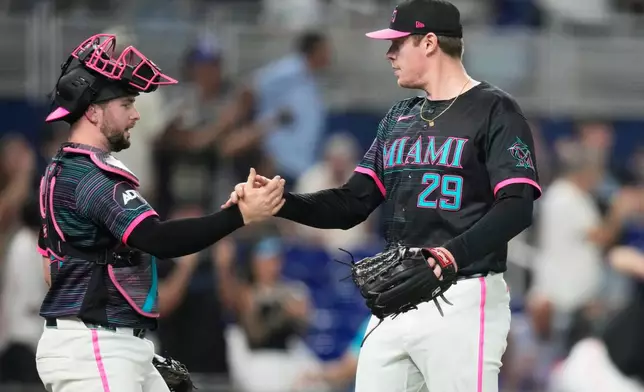 Miami Marlins relief pitcher Pete Fairbanks (29) shakes hands with catcher Joe Mack, left, after the Marlins defeated the San Francisco Giants during a baseball game, Friday, June 19, 2026, in Miami. (AP Photo/Lynne Sladky)