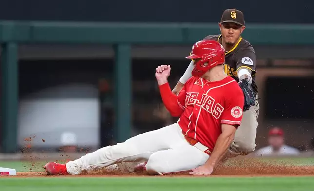 Texas Rangers' Wyatt Langford, left, is tagged out by San Diego Padres third baseman Manny Machado (13) trying to advance to third base on a single by Rangers' Brandon Nimmo during the fourth inning of a baseball game, Saturday, June 20, 2026, in Arlington, Texas. (AP Photo/LM Otero)