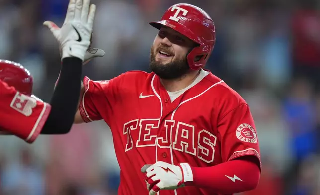 Texas Rangers' Jake Burger celebrates after his home home run that also scored teammate Jarred Kelenic during the seventh inning of a baseball game against the San Diego Padres, Saturday, June 20, 2026, in Arlington, Texas. (AP Photo/LM Otero)
