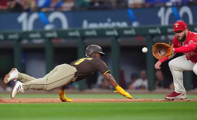 San Diego Padres' Samad Taylor (0) is caught off first base by the pick off throw to Texas Rangers first baseman Jake Burger (21) for the out during the first inning of a baseball game, Saturday, June 20, 2026, in Arlington, Texas. (AP Photo/LM Otero)