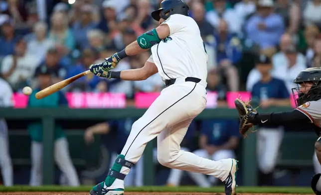 Seattle Mariners' Cal Raleigh hits a two-run single during the seventh inning in a baseball game against the Baltimore Orioles, Tuesday, June 16, 2026, in Seattle. (AP Photo/John Froschauer)