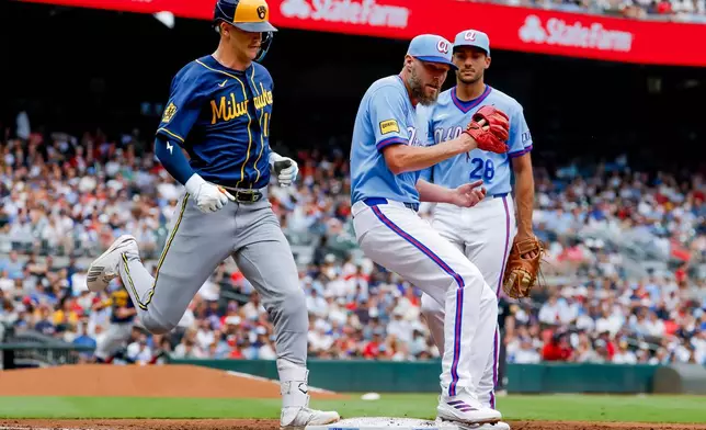 Atlanta Braves pitcher Chris Sale, front right, beats Milwaukee Brewers' Cooper Pratt, left, to first base for a groundout during the second inning of a baseball game, Saturday, June 20, 2026, in Atlanta. (AP Photo/Erik S. Lesser)