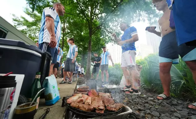 Argentina supporters grill during a rally ahead of their team's World Cup Group J soccer match against Austria, Sunday, June 21, 2026, in Dallas. (AP Photo/Julio Cortez)