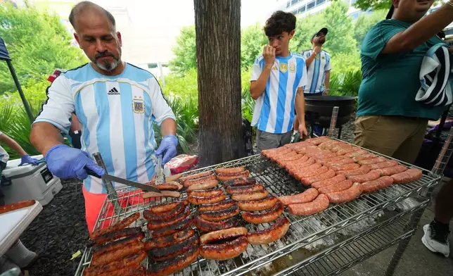 An Argentina supporter grills sausages during a rally ahead of his team's World Cup Group J soccer match against Austria, Sunday, June 21, 2026, in Dallas. (AP Photo/Julio Cortez)