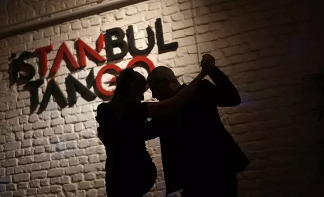 A couple dances tango during a milonga session at 333, a tango studio in Istanbul, Turkey, early Saturday, Jan. 10, 2026. (AP Photo/Francisco Seco)