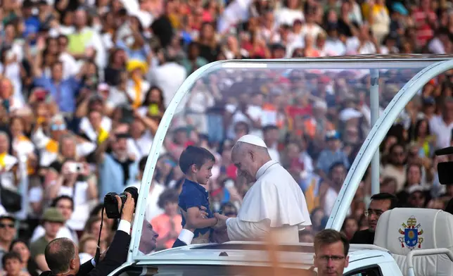 Pope Leo XIV blesses a child before a prayer vigil at Lluis Companys Olympic Stadium in Barcelona, Spain, Tuesday, June 9, 2026. (AP Photo/Emilio Morenatti)