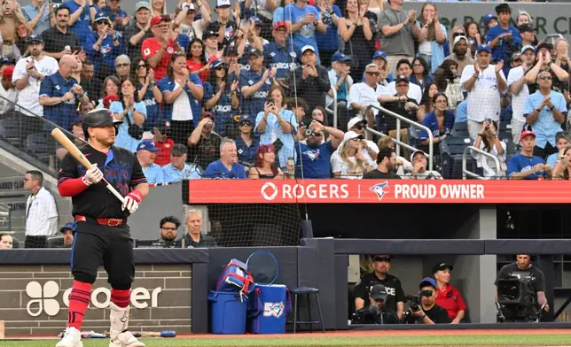 Toronto Blue Jays' Alejandro Kirk, left, is met with applause while taking his first at-bat since retuning to the lineup from the injured list during the first inning of a baseball game against the New York Yankees in Toronto, Friday, June 12, 2026. (Jon Blacker/The Canadian Press via AP)