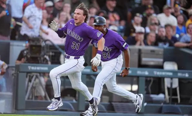 Colorado Rockies' Jake McCarthy, left, makes the turn as third base coach Andy González, right, directs him to home plate to notch an inside-the-park home run off Pittsburgh Pirates starting pitcher Paul Skenes in the first inning of a baseball game Saturday, June 20, 2026, in Denver. (AP Photo/David Zalubowski)