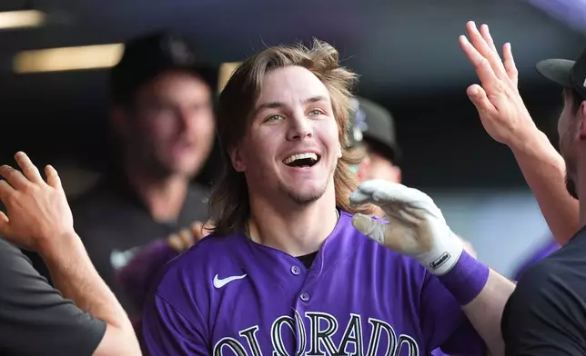Colorado Rockies' Jake McCarthy is congratulated as he returns to the dugout after hitting an inside-the-park home run off Pittsburgh Pirates starting pitcher Paul Skenes in the first inning of a baseball game Saturday, June 20, 2026, in Denver. (AP Photo/David Zalubowski)