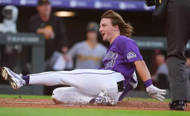 Colorado Rockies' Jake McCarthy slides safely across home plate to notch an inside-the-park home run off Pittsburgh Pirates starting pitcher Paul Skenes in the first inning of a baseball game Saturday, June 20, 2026, in Denver. (AP Photo/David Zalubowski)