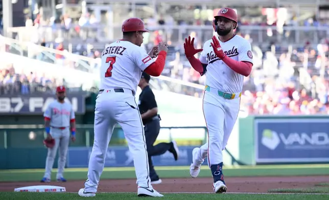 Washington Nationals' Luis Garcia Jr., right, celebrates his home run with third base coach Victor Estevez (7) during the first inning of a baseball game against the Philadelphia Phillies, Wednesday, June 24, 2026, in Washington. (AP Photo/Nick Wass)