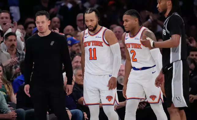 New York Knicks guard Jalen Brunson (11) and guard Miles McBride (2) walk to their bench as San Antonio Spurs head coach Mitch Johnson, left, looks away during second half of Game 3 of the NBA Finals basketball series, Monday, June 8, 2026, in New York. (AP Photo/Ross D. Franklin)