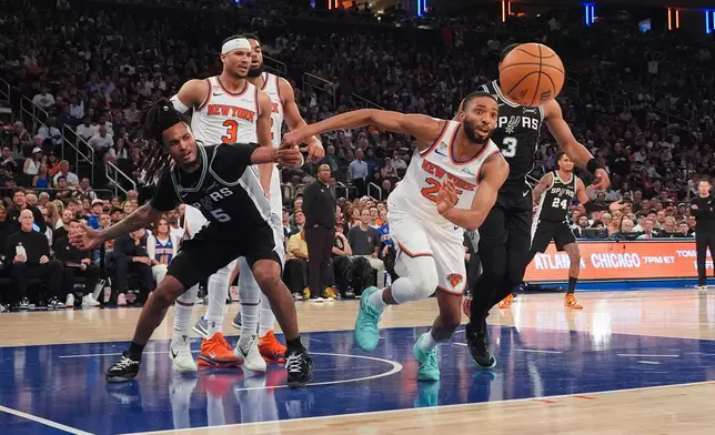 New York Knicks guard Mikal Bridges (25) and San Antonio Spurs guard Stephon Castle (5) chase down the lose ball during second half of Game 3 of the NBA Finals basketball series, Monday, June 8, 2026, in New York. (AP Photo/Ross D. Franklin)