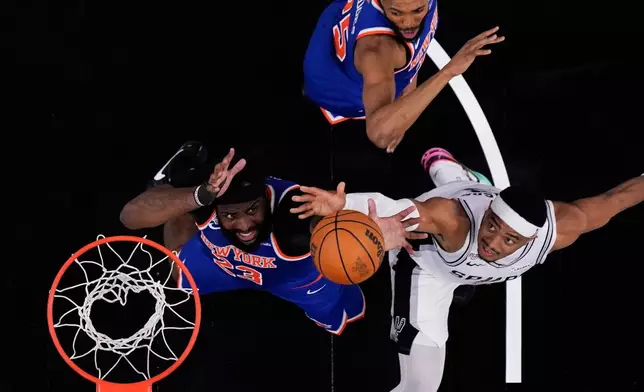 San Antonio Spurs forward Keldon Johnson, right, and New York Knicks center Mitchell Robinson (23) battle for the ball during the second half of Game 2 of the NBA Finals basketball series, Friday, June 5, 2026, in San Antonio. (AP Photo/Eric Gay)