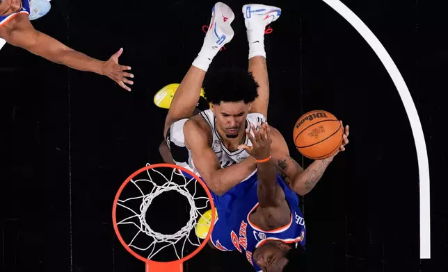 San Antonio Spurs guard Dylan Harper shoots as New York Knicks forward Og Anunoby defends during the second half of Game 2 of the NBA Finals basketball series, Friday, June 5, 2026, in San Antonio. (AP Photo/Eric Gay)