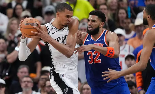San Antonio Spurs forward Victor Wembanyama drives on New York Knicks center Karl-Anthony Towns (32) during the second half of Game 2 of the NBA Finals basketball series, Friday, June 5, 2026, in San Antonio. (AP Photo/Eric Gay)