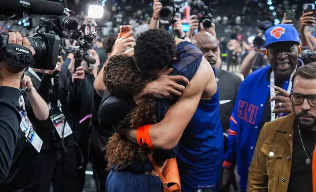 New York Knicks center Karl-Anthony Towns is embraces as he leaves the court after Game 2 of the NBA Finals basketball series against the San Antonio Spurs, Friday, June 5, 2026, in San Antonio. (AP Photo/Eric Gay)