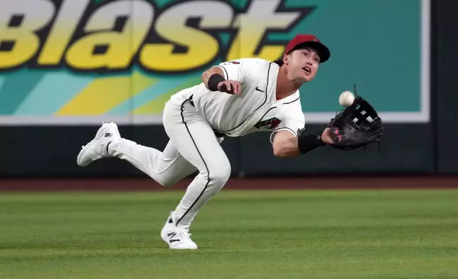 Arizona Diamondbacks outfielder Tommy Troy cannot catch a ball hit by Los Angeles Dodgers' Andy Pages in the third inning of a baseball game, Monday, June 1, 2026, in Phoenix. (AP Photo/Rick Scuteri)