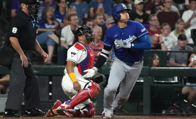 Los Angeles Dodgers' Shohei Ohtani, right, watches his single against the Arizona Diamondbacks in the fifth inning of a baseball game, Monday, June 1, 2026, in Phoenix. (AP Photo/Rick Scuteri)