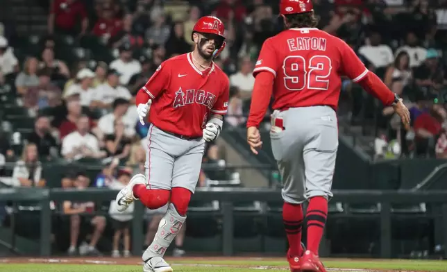 Los Angeles Angels' Zach Neto celebrates with first base coach Adam Eaton (92) after hitting a solo home run against the Arizona Diamondbacks in the third inning of a baseball game, Tuesday, June 16, 2026, in Phoenix. (AP Photo/Rick Scuteri)