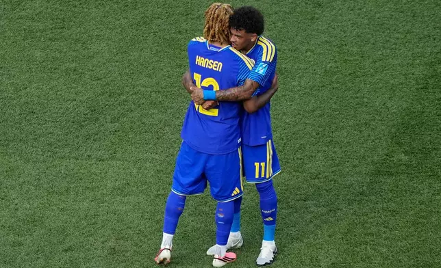 Curaçao's Sontje Hansen (12) and Curaçao's Jeremy Antonisse (11) embrace after the World Cup Group E soccer match between Curacao and Ivory Coast in Philadelphia, Thursday, June 25, 2026. (AP Photo/Matt Slocum)