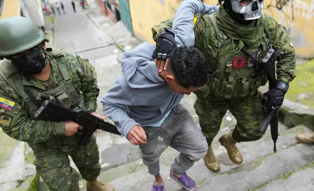 FILE - Soldiers briefly detain a youth to walk him to an area to check if he has gang-related tattoos as they patrol the south side of Quito, Ecuador, Jan. 12, 2024, in the wake of the apparent escape of a powerful gang leader from prison. (AP Photo/Dolores Ochoa, File)