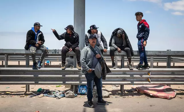 FILE - Migrants, mostly from Venezuela, wait to cross into Peru at the Chacalluta border crossing point in Arica, Chile, Nov. 28, 2025. (AP Photo/Ibar Silva, File)