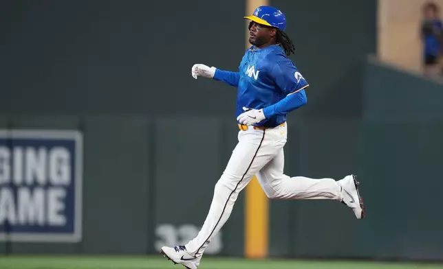 Minnesota Twins' Josh Bell runs to second base after hitting an RBI double during the sixth inning of a baseball game against the Kansas City Royals, Friday, June 5, 2026, in Minneapolis. (AP Photo/Abbie Parr)