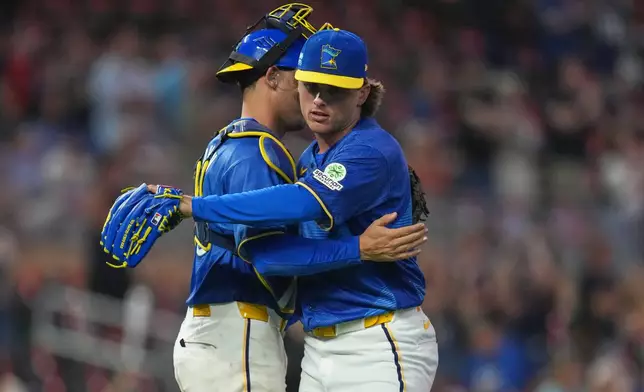 Minnesota Twins catcher Alex Jackson, left, and relief pitcher Travis Adams, right, hug after a baseball game against the Kansas City Royals, Friday, June 5, 2026, in Minneapolis. (AP Photo/Abbie Parr)