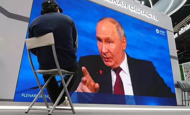 A participant watches a broadcast of Russian President Vladimir Putin's speech on a TV screen during a plenary session of the St. Petersburg International Economic Forum in St. Petersburg, Russia, Friday, June 5, 2026. (AP Photo/Dmitri Lovetsky)